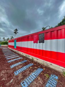 un train rouge et blanc est garé dans un parking dans l'établissement Casa Garfio, à Barra de Navidad