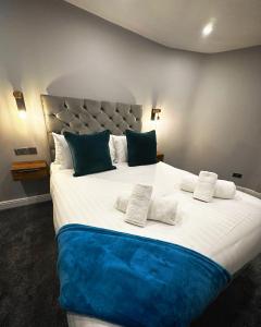 a large bed with blue and white sheets and pillows at 1 West End Boutique Apartment in Bowness-on-Windermere