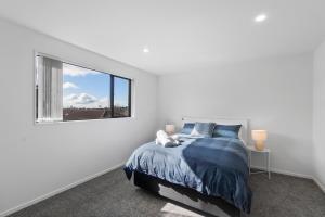 ein weißes Schlafzimmer mit einem Bett und einem Fenster in der Unterkunft New house walk to Rototuna shopping Centre in Hamilton
