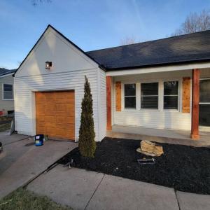 a house with a garage and a tree in front of it at Freshly-remodeled, dog-friendly Westwood charmer! 