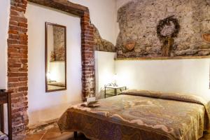 1 dormitorio con cama y pared de ladrillo en Il Cortile, en Civitella Marittima