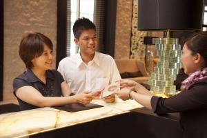 un grupo de tres personas de pie alrededor de una mesa en DoubleTree by Hilton Hotel Naha en Naha