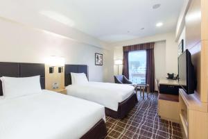 Postel nebo postele na pokoji v ubytování DoubleTree by Hilton Naha