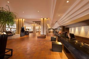 vestíbulo de un edificio con escritorios y sillas en DoubleTree by Hilton Hotel Naha Shuri Castle en Naha