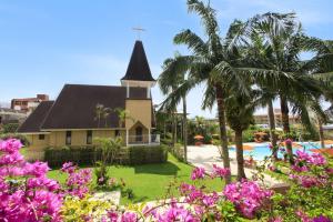 a church with a palm tree and a pool at DoubleTree by Hilton Hotel Naha Shuri Castle in Naha