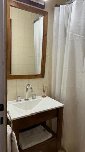 uma casa de banho com um lavatório branco e um espelho. em Nueva Serena em San Carlos de Bariloche