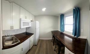 a kitchen with white cabinets and a wooden counter top at Silver Moon Motel & Suites in Saratoga