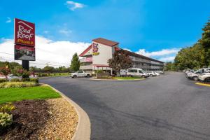 a parking lot with a red roof pizzeria at Red Roof Inn PLUS+ Nashville Airport in Nashville