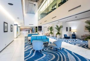 a lobby with blue couches and chairs on a rug at Hilton Surfers Paradise Hotel & Residences in Gold Coast