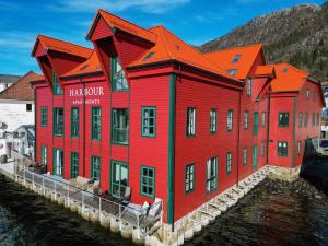 een rood gebouw naast een waterlichaam bij Central Seafront Apartments with Parking and Self Check-In! in Bergen