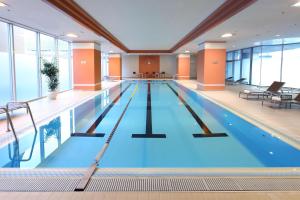 a large indoor swimming pool with blue water at Hilton Osaka Hotel in Osaka