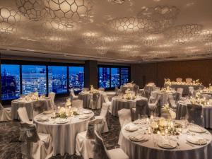 a banquet room with white tables and chairs and windows at Hilton Osaka Hotel in Osaka