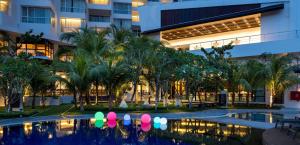 a hotel courtyard with a swimming pool and palm trees at DoubleTree Resort by Hilton Hotel Penang in Batu Ferringhi