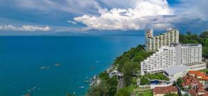 a large building on a hill next to the water at DoubleTree Resort by Hilton Hotel Penang in Batu Ferringhi
