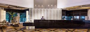 a woman standing behind a reception desk in a lobby at DoubleTree Resort by Hilton Hotel Penang in Batu Ferringhi