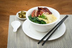 a bowl of food sitting on a plate with chopsticks at DoubleTree Resort by Hilton Hotel Penang in Batu Ferringhi