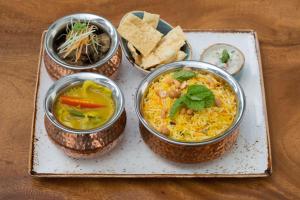 four bowls of food on a plate on a table at DoubleTree Resort by Hilton Hotel Penang in Batu Ferringhi