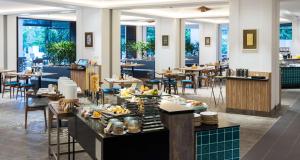 a restaurant with tables and chairs with food on display at DoubleTree Resort by Hilton Hotel Penang in Batu Ferringhi