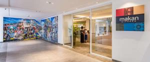 a woman taking a picture in a building with paintings on the wall at DoubleTree Resort by Hilton Hotel Penang in Batu Ferringhi