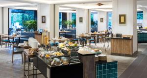 a restaurant with tables and chairs with food on display at DoubleTree Resort by Hilton Hotel Penang in Batu Ferringhi