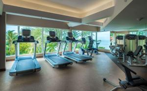 a gym with treadmills and ellipticals in a room with windows at DoubleTree Resort by Hilton Hotel Penang in Batu Ferringhi