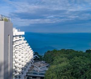 a view of a building with the ocean in the background at DoubleTree Resort by Hilton Hotel Penang in Batu Ferringhi