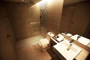 a bathroom with a sink and a toilet and a mirror at DoubleTree Resort by Hilton Hotel Penang in Batu Ferringhi