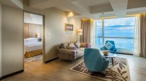 a hotel room with a bed and a couch and a table at DoubleTree Resort by Hilton Hotel Penang in Batu Ferringhi