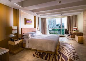 a hotel room with a bed and a large window at DoubleTree Resort by Hilton Hotel Penang in Batu Ferringhi