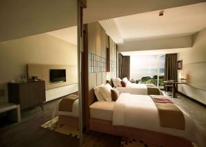 Habitación de hotel con cama grande y TV en DoubleTree Resort by Hilton Hotel Penang, en Batu Ferringhi