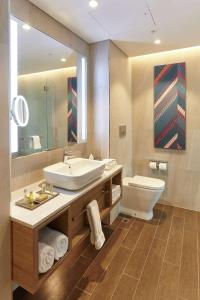 a bathroom with a sink and a toilet and a mirror at Doubletree By Hilton Perth Northbridge in Perth