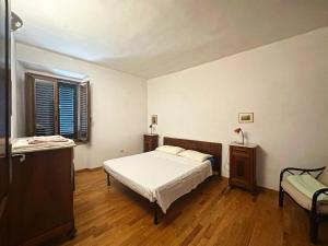 ein Schlafzimmer mit einem Bett, einem Stuhl und einem Fenster in der Unterkunft Casa Renata in Arcidosso