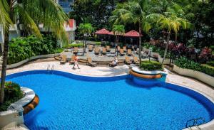 a swimming pool in a resort with palm trees at Hilton Petaling Jaya in Petaling Jaya