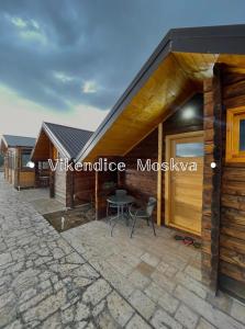 ein Haus mit einer Terrasse mit einem Tisch in der Unterkunft Vikendice Moskva Uvac in Sjenica