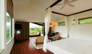 a bedroom with a bed and a living room at Hilton Shillim Estate Retreat and Spa in Lonavala