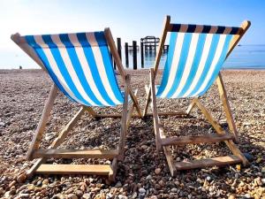 two beach chairs sitting on a rocky beach at Cute Fisherman's Cottage in the Heart of Brighton in Brighton & Hove