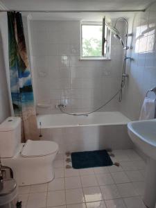 a bathroom with a tub and a toilet and a sink at Panorama house leika kalamatas in Kalamata