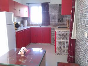a kitchen with red cabinets and a counter top at Dar Amphora Menzel in Midoun