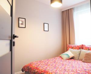 1 dormitorio con 1 cama con colcha de flores en Republiki, en Cracovia