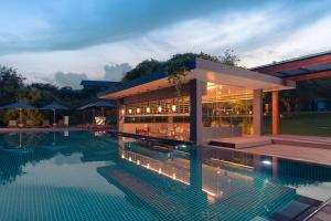 un edificio con piscina di fronte ad esso di Doubletree By Hilton Weerawila Rajawarna Resort a Weerawila