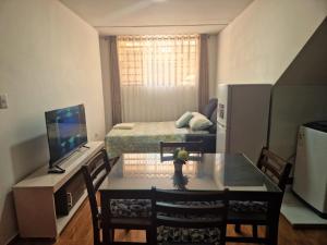 un petit salon avec une table et une télévision dans l'établissement Departamento con entrada independiente en Arequipa, à Santa Rosa