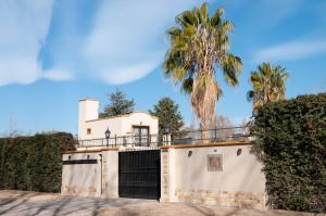 a house with a gate and a palm tree at La Moni in Las Compuertas