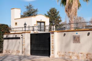 une maison blanche avec une porte noire et un palmier dans l'établissement La Moni, à Las Compuertas