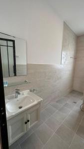 a white bathroom with a sink and a mirror at Cielo Beach Resort 