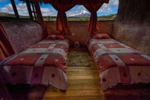 2 camas en una habitación con ventana en MAUCA PEDREGAL en Machachi