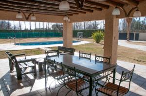 une terrasse avec une table, des chaises et une piscine dans l'établissement La Moni, à Las Compuertas