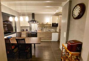 a kitchen with a table and a clock on the wall at Maison Cozy de Gap in Gap