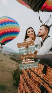 a man and woman riding in a hot air balloon at Morada perto dos Canyons e Balões - Rosa dos Canyons in Praia Grande