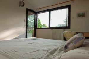 a bedroom with a large bed with a large window at Maison Cozy de Gap in Gap