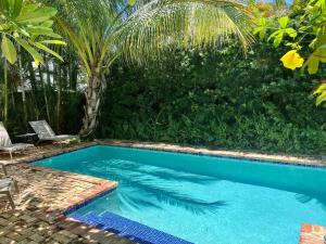 uma piscina com uma palmeira num quintal em Casa Paradiso 3bd 2ba Private Pool and Cabana em West Palm Beach